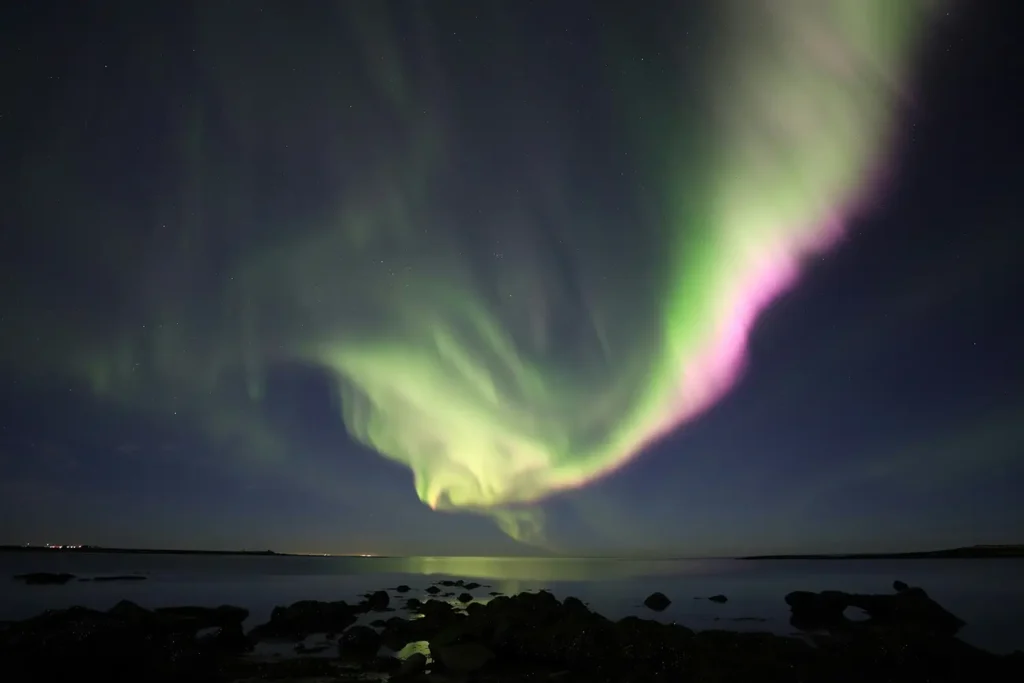 northern lights in sky over water in iceland